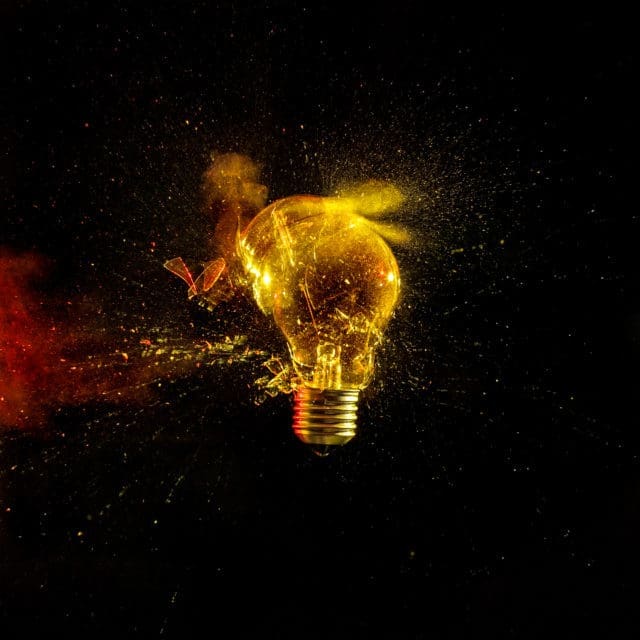 Close-Up Of Broken Light Bulb Against Black Background